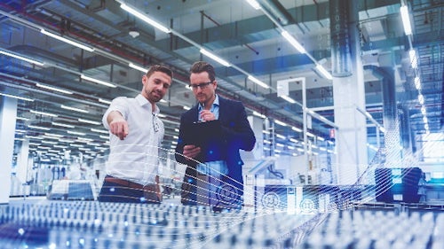 Two men working in a factory examine product to ensure quality management and continuous improvement